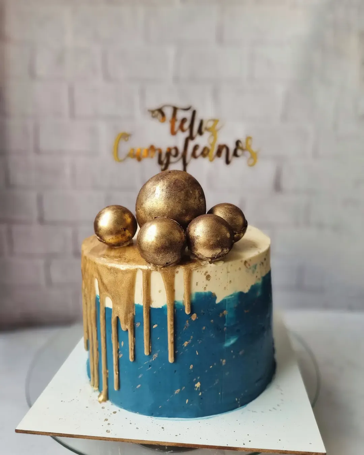 Torta azul y dorada con esferas para cumpleaños