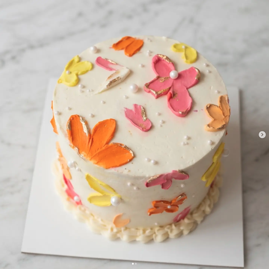 Torta personalizada de mariposas en tonos rosa, naranja y amarillo